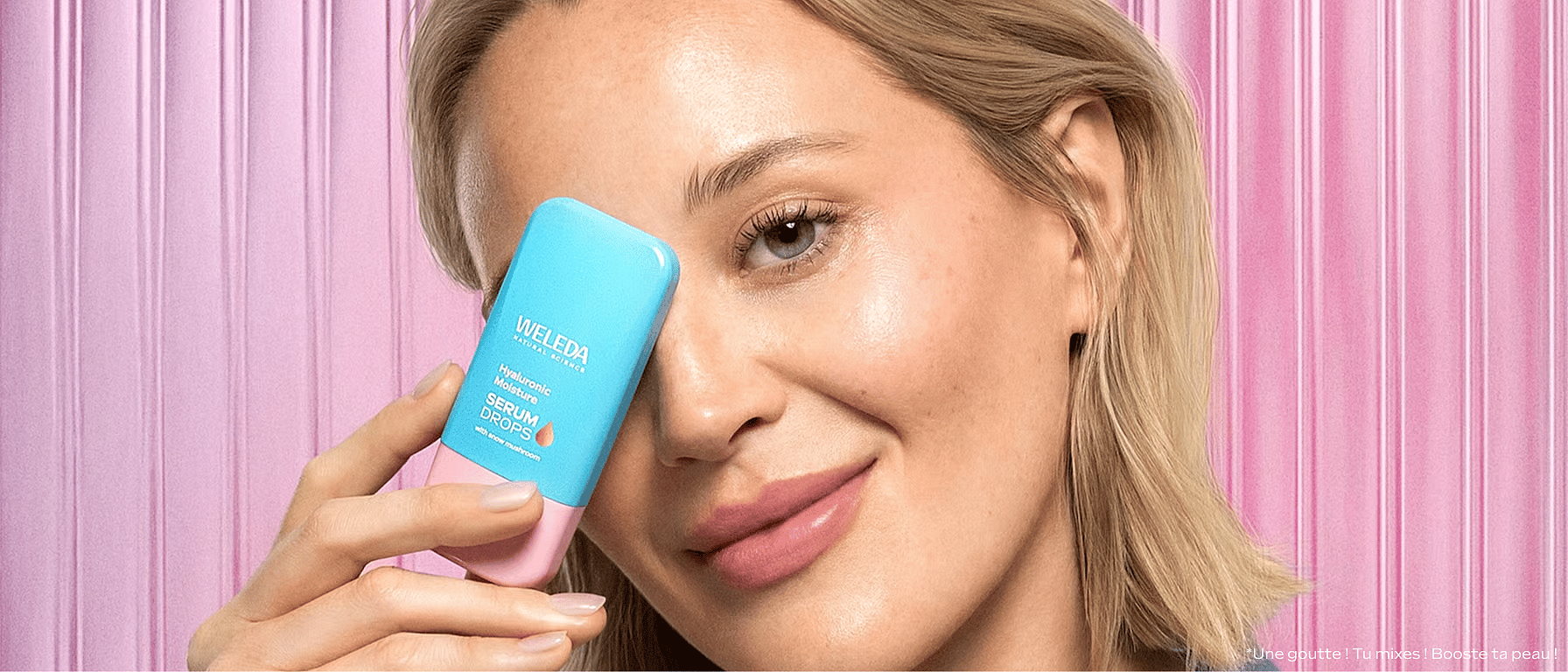 jeune femme blonde tenant le booster drop Hyaluronic Serum devant son visage