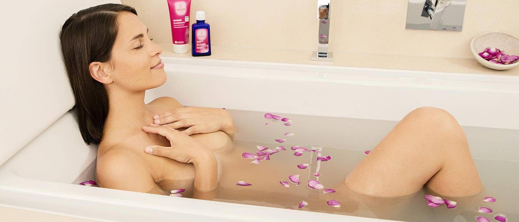 femme dans son bain avec des pétales de fleurs