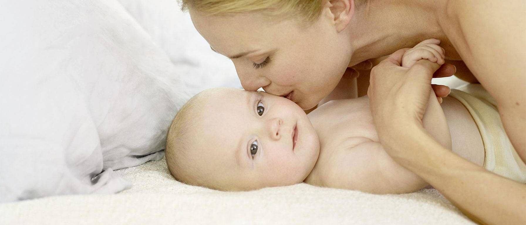 mother kissing baby