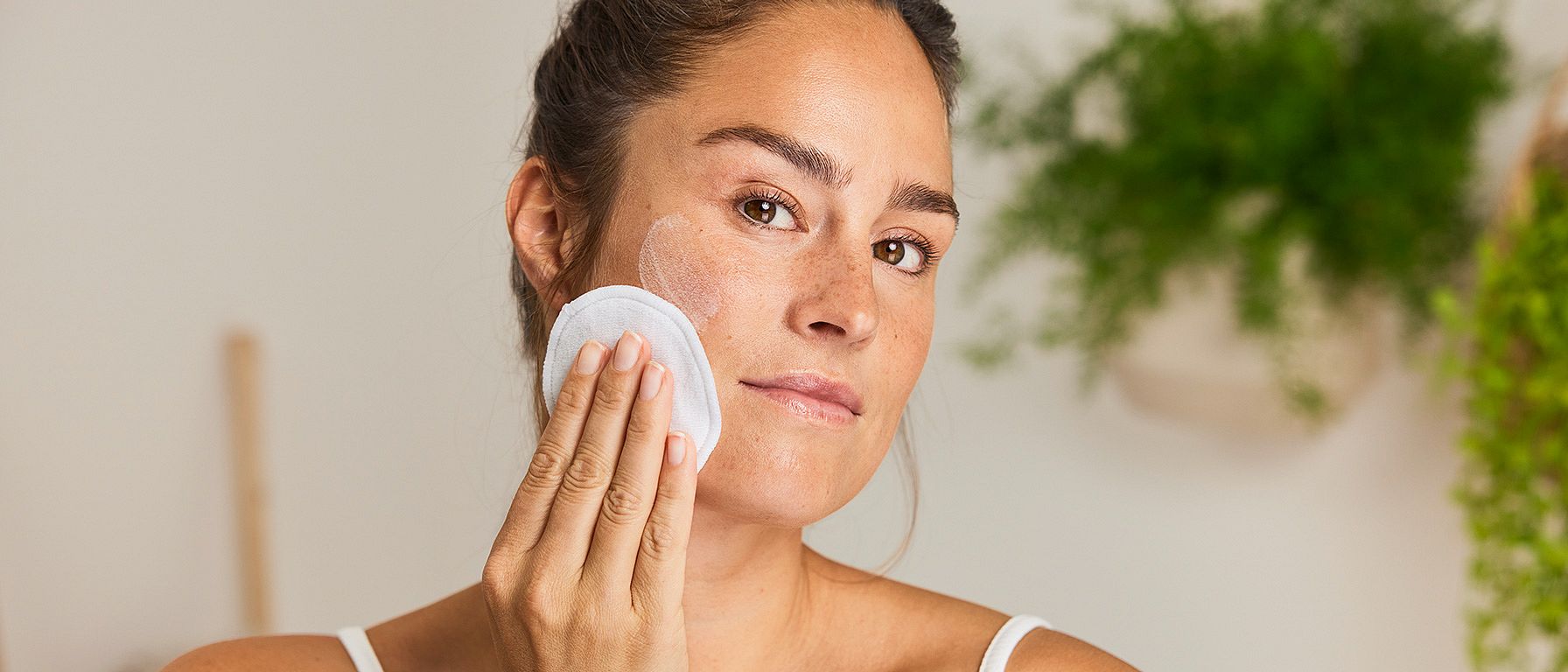une femme se nettoie le visage