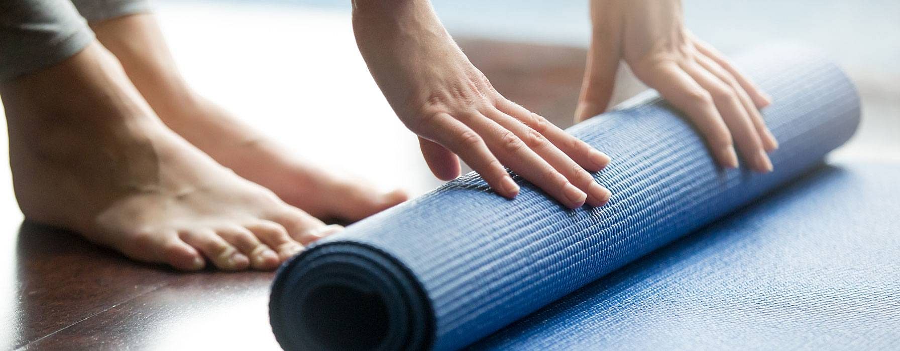 Une femme roule sur un tapis d'exercice