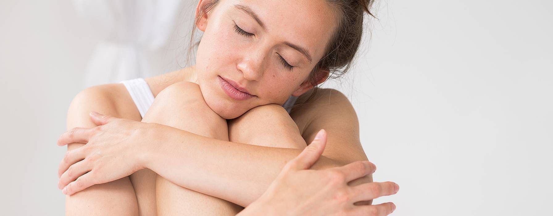 femme assise qui se fait un calin