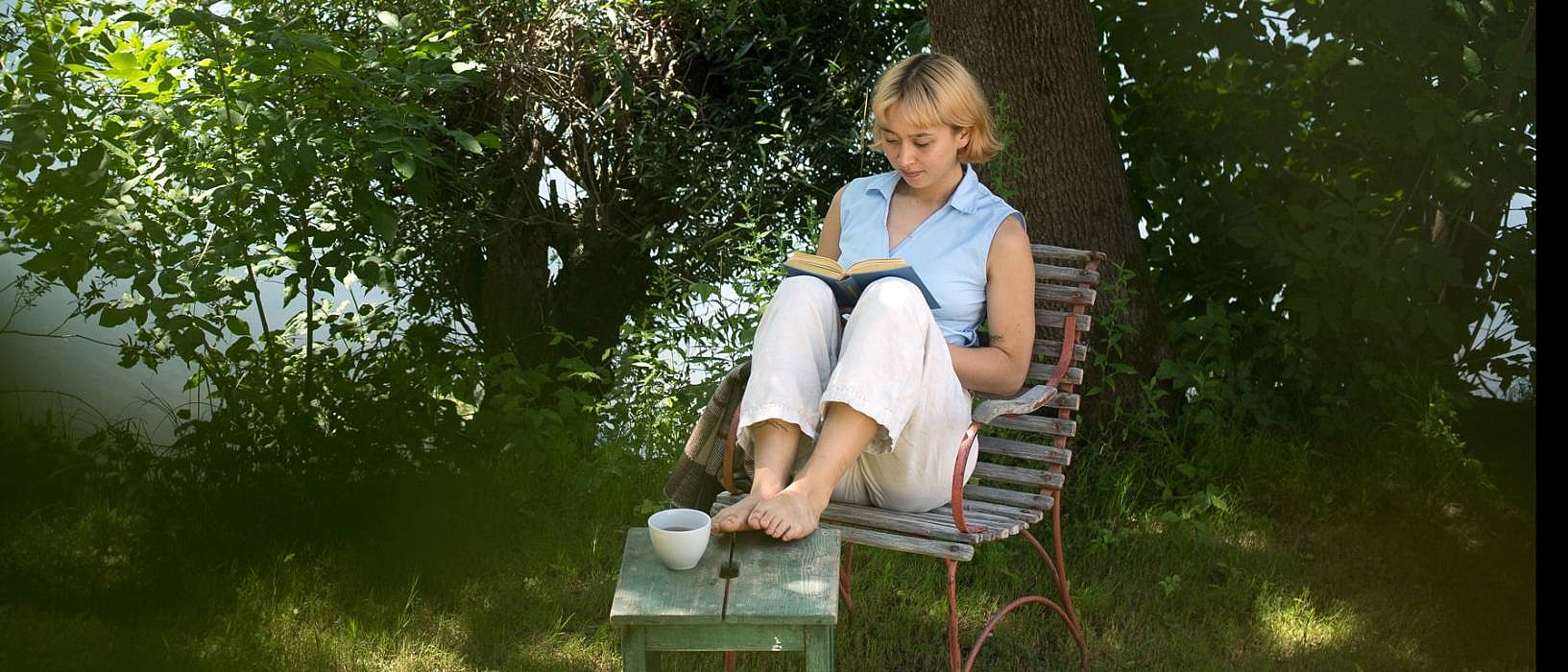 femme qui lit un livre assise dans la nature