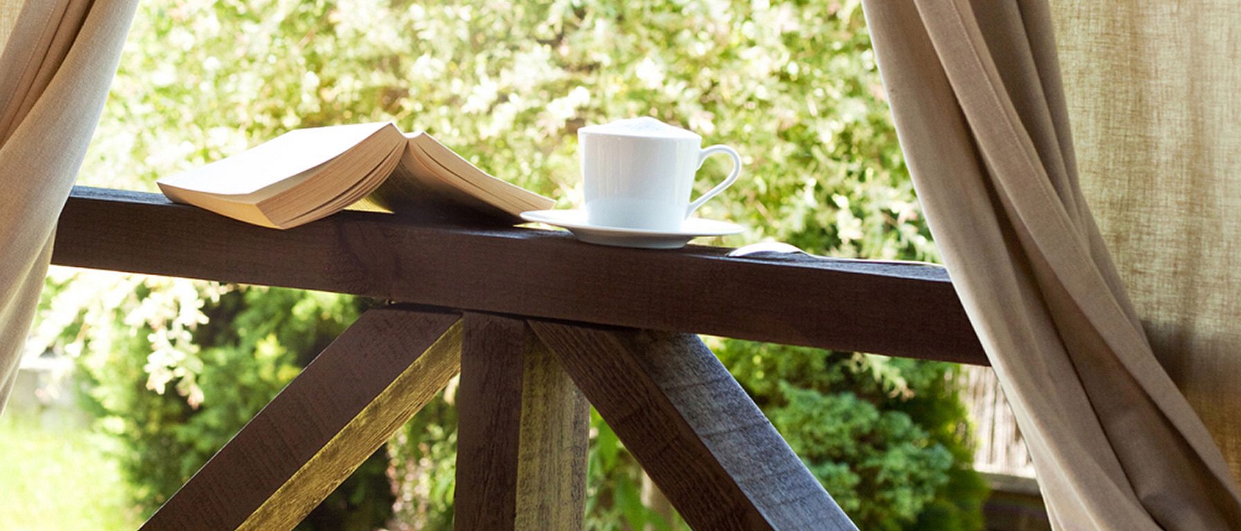 Livre, tasse de thé à la fenêtre avec vue sur la nature extérieure