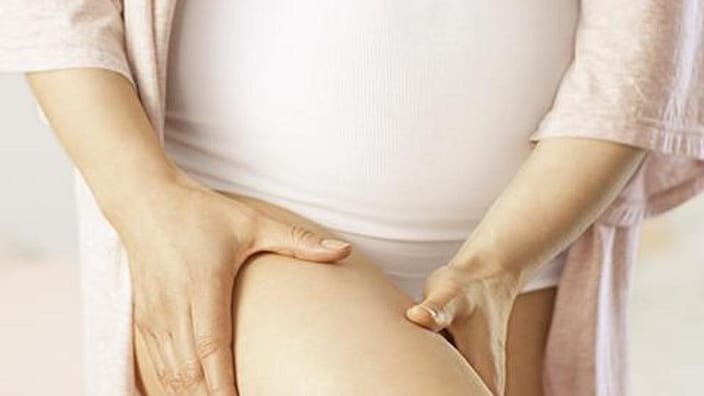 femme enceinte qui se masse les cuisses