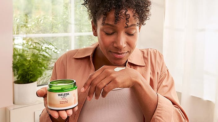Une femme sent la crème sur sa main