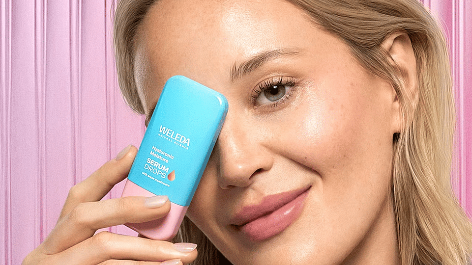 jeune femme blonde tenant le booster drop Hyaluronic Serum devant son visage