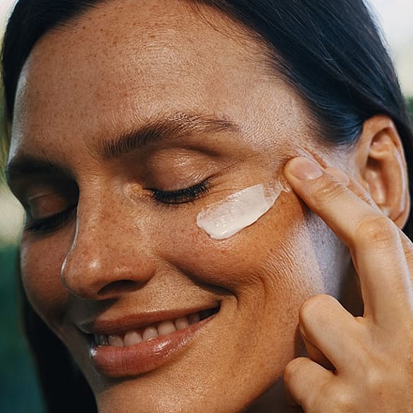 femme avec de la crème sur le visage