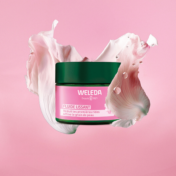 Junge Frau hält sich das Weleda Wildrose Skin Repair Serum and die Wange