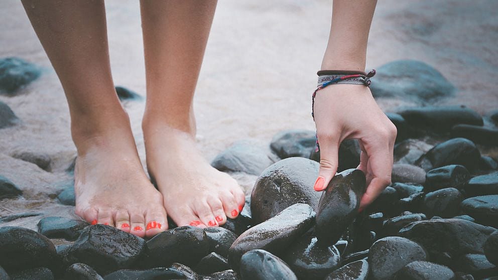 pieds ongles rouges sur une pierre
