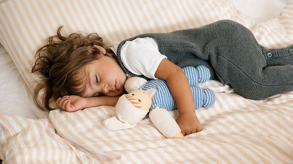 enfant qui dort avec peluche