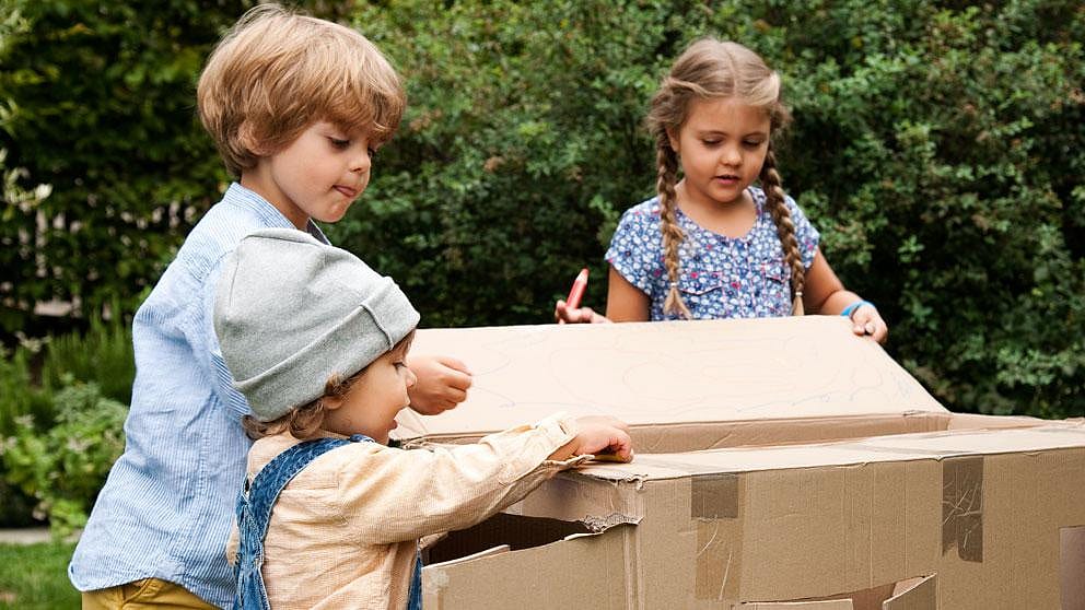 enfants qui jouent dans des cartons