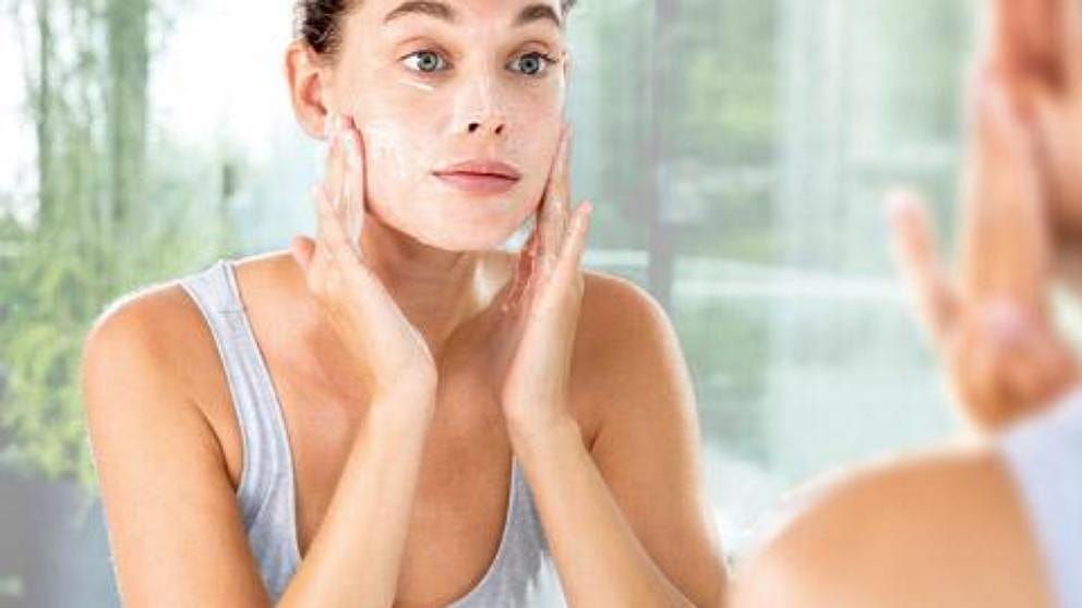 femme se lavant le visage salle de bain