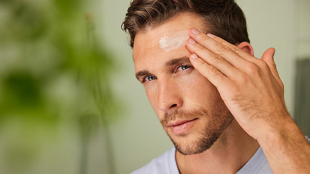 l'homme utilise une crème hydratante