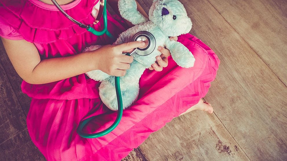 enfant qui joue au docteur avec peluche