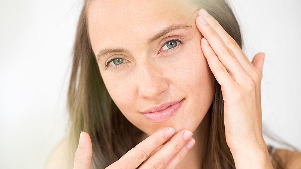 femme se touche le visage